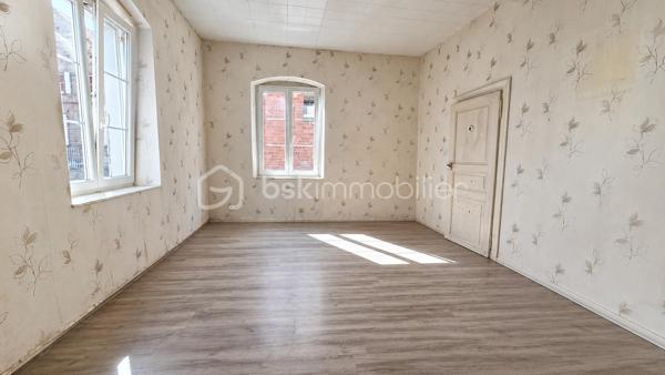 # 🏡 Maison de caractère 188 m² à rénover entièrement – Potentiel 2 à 4 logements – Idéale grande famille ou investisseur

**Au cœur de la cité Vauban de Neuf-Brisach**, découvrez cette authentique maison de caractère d'environ **188 m² habitables**, offrant de beaux volumes et un remarquable potentiel d'aménagement.

Que vous soyez à la recherche d'une **grande maison familiale** ou d'un **projet d'investissement**, cette propriété saura vous séduire par ses nombreuses possibilités d'évolution.

## Une configuration idéale

Le bien est actuellement organisé sur plusieurs niveaux :

### Sous-sol

* Cave.

### Rez-de-chaussée

Un **sas de distribution indépendant** dessert le logement du rez-de-chaussée, la cave ainsi que les étages supérieurs. Il comprend également un **espace dédié au stockage des ordures ménagères**, particulièrement pratique dans le cadre d'un projet locatif.

Le **logement du rez-de-chaussée** comprend :

* Entrée
* Cuisine
* Salon
* Séjour
* Deux chambres
* Pièce annexe
* Salle d'eau
* WC

### Étage

Un second logement comprend :

* Entrée
* Cuisine
* Salon
* Trois chambres
* Salle de bains
* WC

### Combles

Les combles offrent un beau potentiel d'aménagement supplémentaire (sous réserve des autorisations administratives).

## Les atouts

✔ Environ **188 m² habitables**

✔ Maison déjà organisée en **deux logements**

✔ Sas de distribution indépendant desservant les différents niveaux

✔ Cave

✔ Combles aménageables

✔ Cour intérieure privative

✔ Maison d'angle lumineuse

✔ Beaux volumes

✔ Fort potentiel de valorisation

## Rénovation complète à prévoir

Cette propriété nécessite **une rénovation totale** (isolation, électricité, plomberie, chauffage, sanitaires, menuiseries, aménagement intérieur et rafraîchissement général).

Ces travaux permettront de révéler tout le potentiel de cette bâtisse et de créer un bien entièrement adapté à votre projet.

## Un bien aux multiples possibilités

Cette propriété s'adresse aussi bien à une **grande famille** en quête d'espace qu'à un **investisseur** ou un **marchand de biens**.

Pour une famille, elle offre la possibilité de créer une vaste résidence principale avec de beaux volumes, de nombreuses chambres, une cour intérieure, une cave et des combles, où chacun pourra profiter de son propre espace.

Pour un investisseur, la configuration actuelle représente une excellente base de travail grâce aux **deux logements existants**, au **sas de distribution indépendant**, à la **cave** et aux **combles**.

**Sous réserve des autorisations administratives, des règles d'urbanisme en vigueur et des études techniques nécessaires, cette propriété offre le potentiel de créer de 2 à 4 logements**, ce qui en fait une opportunité particulièrement intéressante pour un projet locatif ou patrimonial.

Après une rénovation complète, cette bâtisse de caractère retrouvera tout son charme et pourra devenir une superbe résidence familiale ou un investissement immobilier à fort potentiel.

**Une opportunité rare au cœur de Neuf-Brisach !**