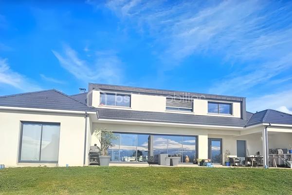À seulement 4 minutes de Pau, sur la commune très prisée de Morlaàs, découvrez cette somptueuse maison contemporaine de 190 m², édifiée il y a moins de 3 ans, offrant des prestations haut de gamme et une vue panoramique exceptionnelle sur la chaîne des Pyrénées.

Dès l’entrée, les volumes généreux et la luminosité naturelle soulignent l’élégance des lignes architecturales. La pièce de vie, chaleureuse et raffinée, s’articule autour d’une cheminée à insert et s’ouvre largement sur une terrasse plein sud, véritable belvédère face aux montagnes.

La cuisine, signée Cuisines Tendances, allie design et fonctionnalité. Elle est complétée par un cellier entièrement aménagé avec espace salle des machines et évier, pensé pour un confort optimal au quotidien. Sous l’escalier, une cave à vin sur-mesure ravira les amateurs éclairés.

La maison propose 4 chambres aux prestations soignées :

Au rez-de-chaussée :
Une superbe suite parentale avec dressing aménagé et salle de bain complète (douche, baignoire, WC japonais).
Une seconde suite indépendante idéale pour recevoir famille et amis, avec sa propre salle d’eau.

À l’étage :
Deux chambres lumineuses avec espaces dressing intégrés.
Une salle de bain supplémentaire.
Un palier aménagé distribuant harmonieusement les espaces nuit.
Le confort est assuré par une climatisation gainable alimentée par pompe à chaleur, garantissant performance énergétique et bien-être en toute saison.
Un garage complète ce bien rare.

Les atouts majeurs :
✔ Vue spectaculaire sur la chaîne des Pyrénées
✔ Secteur recherché et environnement privilégié
✔ Maison récente (moins de 3 ans)
✔ Prestations haut de gamme
✔ À proximité immédiate de Pau

Une propriété d’exception alliant modernité, confort et panorama unique, destinée à une clientèle en quête d’exclusivité et de qualité de vie.

689.000 euros frais d'agence inclus