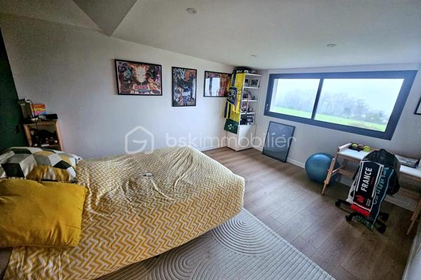 À seulement 4 minutes de Pau, sur la commune très prisée de Morlaàs, découvrez cette somptueuse maison contemporaine de 190 m², édifiée il y a moins de 3 ans, offrant des prestations haut de gamme et une vue panoramique exceptionnelle sur la chaîne des Pyrénées.

Dès l’entrée, les volumes généreux et la luminosité naturelle soulignent l’élégance des lignes architecturales. La pièce de vie, chaleureuse et raffinée, s’articule autour d’une cheminée à insert et s’ouvre largement sur une terrasse plein sud, véritable belvédère face aux montagnes.

La cuisine, signée Cuisines Tendances, allie design et fonctionnalité. Elle est complétée par un cellier entièrement aménagé avec espace salle des machines et évier, pensé pour un confort optimal au quotidien. Sous l’escalier, une cave à vin sur-mesure ravira les amateurs éclairés.

La maison propose 4 chambres aux prestations soignées :

Au rez-de-chaussée :
Une superbe suite parentale avec dressing aménagé et salle de bain complète (douche, baignoire, WC japonais).
Une seconde suite indépendante idéale pour recevoir famille et amis, avec sa propre salle d’eau.

À l’étage :
Deux chambres lumineuses avec espaces dressing intégrés.
Une salle de bain supplémentaire.
Un palier aménagé distribuant harmonieusement les espaces nuit.
Le confort est assuré par une climatisation gainable alimentée par pompe à chaleur, garantissant performance énergétique et bien-être en toute saison.
Un garage complète ce bien rare.

Les atouts majeurs :
✔ Vue spectaculaire sur la chaîne des Pyrénées
✔ Secteur recherché et environnement privilégié
✔ Maison récente (moins de 3 ans)
✔ Prestations haut de gamme
✔ À proximité immédiate de Pau

Une propriété d’exception alliant modernité, confort et panorama unique, destinée à une clientèle en quête d’exclusivité et de qualité de vie.

689.000 euros frais d'agence inclus