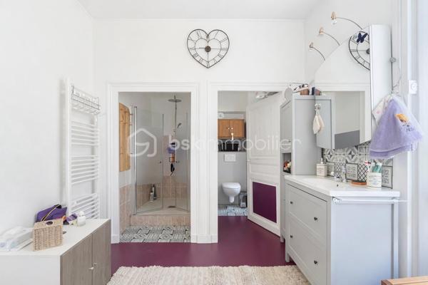 Et si votre prochain appartement ressemblait davantage à une maison de campagne qu'à un logement en copropriété ?
Au sein d'une élégante demeure du XIXe siècle divisée en seulement cinq appartements, découvrez un lieu de vie rare et préservé, niché dans un magnifique parc privé clos de plus de 1,5 hectare.

Dès votre arrivée, le charme opère. La majesté des arbres centenaires et le caractère authentique de la bâtisse créent une atmosphère unique, difficile à retrouver sur le marché.
Situé en rez-de-chaussée, cet appartement d'environ 100m² (98,78m² Carrez) séduit immédiatement par ses volumes généreux et ses éléments anciens parfaitement conservés : belle hauteur sous plafond, pierres apparentes, larges ouvertures laissant entrer la lumière naturelle.
L'agencement est à la fois fonctionnel et chaleureux. Une entrée dessert un agréable séjour-salle à manger d'environ 30m² ouvert sur une terrasse privative offrant une vue imprenable sur le parc. Un véritable privilège au quotidien.
La cuisine indépendante, récemment rénovée, allie confort et modernité.
L'espace nuit comprend deux belles chambres ainsi qu'une pièce supplémentaire d'environ 9m² pouvant accueillir selon vos besoins une chambre d'enfant, un bureau ou un espace dédié au télétravail.
Une vaste salle de bains avec douche, WC et espace buanderie complète harmonieusement l'ensemble.

Les atouts qui font toute la différence
- Parc privé clos de plus de 1,5 hectare
- Demeure de caractère du XIXe siècle
- Seulement 5 copropriétaires
- Terrasse avec vue dégagée sur le parc
- Belle hauteur sous plafond et pierres apparentes
- Cuisine récemment rénovée
- Chauffage collectif au gaz et eau froide inclus dans les charges
- Cave voûtée en sous-sol
- Deux places de stationnement privatives
- Accès rapide aux principaux axes routiers

Un bien rare pour les amoureux de caractère
Cet appartement ne s'adresse pas à ceux qui recherchent un bien standard.
Il séduira les acquéreurs en quête d'un cadre de vie privilégié, d'authenticité et d'un environnement verdoyant exceptionnel, tout en conservant la proximité des commodités. Une adresse confidentielle, un parc remarquable et le charme intemporel de l'ancien : un bien coup de cœur à découvrir sans tarder.

Visites exclusivement sur rendez-vous.