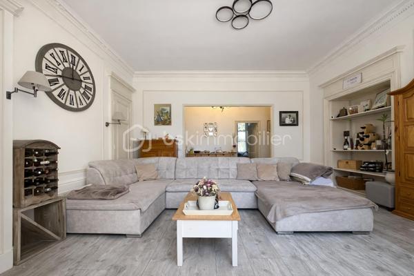 Et si votre prochain appartement ressemblait davantage à une maison de campagne qu'à un logement en copropriété ?
Au sein d'une élégante demeure du XIXe siècle divisée en seulement cinq appartements, découvrez un lieu de vie rare et préservé, niché dans un magnifique parc privé clos de plus de 1,5 hectare.

Dès votre arrivée, le charme opère. La majesté des arbres centenaires et le caractère authentique de la bâtisse créent une atmosphère unique, difficile à retrouver sur le marché.
Situé en rez-de-chaussée, cet appartement d'environ 100m² (98,78m² Carrez) séduit immédiatement par ses volumes généreux et ses éléments anciens parfaitement conservés : belle hauteur sous plafond, pierres apparentes, larges ouvertures laissant entrer la lumière naturelle.
L'agencement est à la fois fonctionnel et chaleureux. Une entrée dessert un agréable séjour-salle à manger d'environ 30m² ouvert sur une terrasse privative offrant une vue imprenable sur le parc. Un véritable privilège au quotidien.
La cuisine indépendante, récemment rénovée, allie confort et modernité.
L'espace nuit comprend deux belles chambres ainsi qu'une pièce supplémentaire d'environ 9m² pouvant accueillir selon vos besoins une chambre d'enfant, un bureau ou un espace dédié au télétravail.
Une vaste salle de bains avec douche, WC et espace buanderie complète harmonieusement l'ensemble.

Les atouts qui font toute la différence
- Parc privé clos de plus de 1,5 hectare
- Demeure de caractère du XIXe siècle
- Seulement 5 copropriétaires
- Terrasse avec vue dégagée sur le parc
- Belle hauteur sous plafond et pierres apparentes
- Cuisine récemment rénovée
- Chauffage collectif au gaz et eau froide inclus dans les charges
- Cave voûtée en sous-sol
- Deux places de stationnement privatives
- Accès rapide aux principaux axes routiers

Un bien rare pour les amoureux de caractère
Cet appartement ne s'adresse pas à ceux qui recherchent un bien standard.
Il séduira les acquéreurs en quête d'un cadre de vie privilégié, d'authenticité et d'un environnement verdoyant exceptionnel, tout en conservant la proximité des commodités. Une adresse confidentielle, un parc remarquable et le charme intemporel de l'ancien : un bien coup de cœur à découvrir sans tarder.

Visites exclusivement sur rendez-vous.