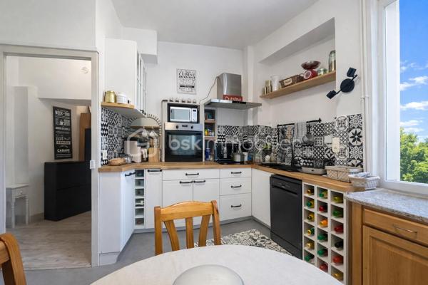 Et si votre prochain appartement ressemblait davantage à une maison de campagne qu'à un logement en copropriété ?
Au sein d'une élégante demeure du XIXe siècle divisée en seulement cinq appartements, découvrez un lieu de vie rare et préservé, niché dans un magnifique parc privé clos de plus de 1,5 hectare.

Dès votre arrivée, le charme opère. La majesté des arbres centenaires et le caractère authentique de la bâtisse créent une atmosphère unique, difficile à retrouver sur le marché.
Situé en rez-de-chaussée, cet appartement d'environ 100m² (98,78m² Carrez) séduit immédiatement par ses volumes généreux et ses éléments anciens parfaitement conservés : belle hauteur sous plafond, pierres apparentes, larges ouvertures laissant entrer la lumière naturelle.
L'agencement est à la fois fonctionnel et chaleureux. Une entrée dessert un agréable séjour-salle à manger d'environ 30m² ouvert sur une terrasse privative offrant une vue imprenable sur le parc. Un véritable privilège au quotidien.
La cuisine indépendante, récemment rénovée, allie confort et modernité.
L'espace nuit comprend deux belles chambres ainsi qu'une pièce supplémentaire d'environ 9m² pouvant accueillir selon vos besoins une chambre d'enfant, un bureau ou un espace dédié au télétravail.
Une vaste salle de bains avec douche, WC et espace buanderie complète harmonieusement l'ensemble.

Les atouts qui font toute la différence
- Parc privé clos de plus de 1,5 hectare
- Demeure de caractère du XIXe siècle
- Seulement 5 copropriétaires
- Terrasse avec vue dégagée sur le parc
- Belle hauteur sous plafond et pierres apparentes
- Cuisine récemment rénovée
- Chauffage collectif au gaz et eau froide inclus dans les charges
- Cave voûtée en sous-sol
- Deux places de stationnement privatives
- Accès rapide aux principaux axes routiers

Un bien rare pour les amoureux de caractère
Cet appartement ne s'adresse pas à ceux qui recherchent un bien standard.
Il séduira les acquéreurs en quête d'un cadre de vie privilégié, d'authenticité et d'un environnement verdoyant exceptionnel, tout en conservant la proximité des commodités. Une adresse confidentielle, un parc remarquable et le charme intemporel de l'ancien : un bien coup de cœur à découvrir sans tarder.

Visites exclusivement sur rendez-vous.