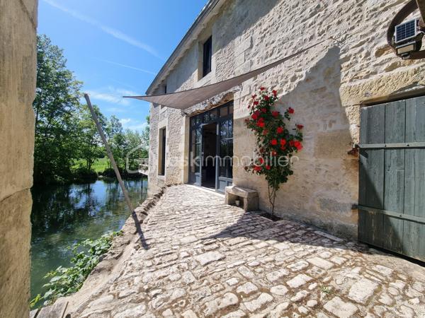 Nous vous proposons ce moulin rénové avec goût totalement isolé. 

Il se compose d'une première partie d'environ 90 m2, composée d'une grande pièce de vie avec cuisine, ouverte sur une terrasse surplombant la rivière. Les grandes ouvertures apportent un bain de lumière au rez-de-chaussée, tout en offrant un sentiment de dehors / dedans et une vue imprenable sur la rivière et le parc.
Il y a également un accès sur l'arrière de la propriété ainsi qu'un WC séparé. Dans la cuisine, une ouverture permet d'accéder au mécanisme du moulin (la roue ayant été supprimée).
A l'étage : une chambre, une salle d'eau avec wc, une mezzanine pouvant servir de deuxième chambre.
Cette première partie est entièrement chauffée par un poêle de masse.
La rénovation a été réalisée avec soin dans l'optique de respecter les éléments anciens du moulin. Les murs sont en chaux/chanvre, les sols sont en travertin au rez-de-chaussée  et en parquet à l'étage. Poutres et pierre subliment également cette espace de vie unique.

En prolongement du bâti, un second logement d'environ 45 m2, permettant d'accueillir famille ou amis, se compose d'une pièce de vie avec cuisine, une chambre, une salle d'eau, WC séparés.

Une autre partie de 165m² environ est composée d'une grande pièce au rez-de-chaussée et de trois pièces à l'étage. Des travaux de rénovation sont actuellement en cours sur cette partie et seront à finir par le futur propriétaire.

De nombreuses dépendances dont une grange de 280 m². Un appentis pouvant abriter un camping car.

Parc de deux hectares.
Idéal Gites.

Situé à 10 minutes de Saint-Maixent-l'Ecole (gare TGV Paris Montparnasse - La Rochelle), 5 minutes des commerces de proximité, école et collège.
