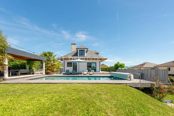 Nouvelle EXCLUSIVITÉ BSK IMMOBILIER !

Vous recherchez une magnifique bâtisse de caractère rénovée avec goût, sur un terrain arboré d’environ 1 000 m² à deux pas du centre-village d’Albens ? Vous êtes au bon endroit !

Située sur les premières hauteurs de la commune, à seulement 1 minute de tous les commerces, venez découvrir cette remarquable propriété de 1968. 
Repensée en 2015, sa rénovation contemporaine lui confère un look californien liant l'intérieur et l'extérieur, idéal pour un cadre de vie haut de gamme et lumineux.

Le grand confort en plus : Pour un bien-être optimal en toutes saisons, la maison est entièrement climatisée au niveau des espaces de vie.

L'intérieur, baigné de lumière, se développe sur deux niveaux parfaitement agencés :

🌟 Le Rez-de-Jardin (Espace de vie principal)

• Vaste pièce de vie ouverte et climatisée comprenant une cuisine équipée, une salle à manger et un séjour avec accès direct à la terrasse entièrement carrelée et au jardin bordant la piscine offrant une vue panoramique imprenable sur les montagnes et la verdure environnante,
• Espace nuit : 3 belles chambres, une salle de bain (avec baignoire et douche) et un WC séparé.

📐 Le Premier Niveau (Idéal enfants ou invités)

• 2 chambres confortables,
• Un second espace de vie climatisé (salon bis, salle de jeux ou home-cinéma),
• Un coin cuisine annexe équipé et une seconde salle de bains.y

🚗 Les Annexes

• Un sous-sol complet avec garage double, buanderie et cave.
• Le petit + : Une véritable salle de sport aménagée pour vos séances à domicile !

🛠️ Prestations & Points Techniques

• Confort thermique : Climatisation sur les niveaux de vie et chauffage par radiateurs reliés à une pompe à chaleur Air/Eau,
• Ouvertures : Menuiseries en aluminium double vitrage, équipées de volets roulants motorisés de type BSO dans la pièce de vie,
• Côté détente : Une superbe piscine (9m x 4m) rénovée en 2015, chauffée et traitée au chlore, parfaite pour prolonger l'ambiance californienne.

Par son emplacement recherché, son panorama et la qualité de ses finitions, cette propriété est un bien rare sur le marché qui saura coup sûr vous séduire.

Contactez-moi dès aujourd'hui pour échanger sur votre projet et organiser une visite exclusive de ce coup de cœur !