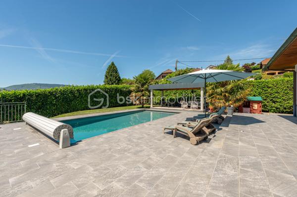 Nouvelle EXCLUSIVITÉ BSK IMMOBILIER !

Vous recherchez une magnifique bâtisse de caractère rénovée avec goût, sur un terrain arboré d’environ 1 000 m² à deux pas du centre-village d’Albens ? Vous êtes au bon endroit !

Située sur les premières hauteurs de la commune, à seulement 1 minute de tous les commerces, venez découvrir cette remarquable propriété de 1968. 
Repensée en 2015, sa rénovation contemporaine lui confère un look californien liant l'intérieur et l'extérieur, idéal pour un cadre de vie haut de gamme et lumineux.

Le grand confort en plus : Pour un bien-être optimal en toutes saisons, la maison est entièrement climatisée au niveau des espaces de vie.

L'intérieur, baigné de lumière, se développe sur deux niveaux parfaitement agencés :

🌟 Le Rez-de-Jardin (Espace de vie principal)

• Vaste pièce de vie ouverte et climatisée comprenant une cuisine équipée, une salle à manger et un séjour avec accès direct à la terrasse entièrement carrelée et au jardin bordant la piscine offrant une vue panoramique imprenable sur les montagnes et la verdure environnante,
• Espace nuit : 3 belles chambres, une salle de bain (avec baignoire et douche) et un WC séparé.

📐 Le Premier Niveau (Idéal enfants ou invités)

• 2 chambres confortables,
• Un second espace de vie climatisé (salon bis, salle de jeux ou home-cinéma),
• Un coin cuisine annexe équipé et une seconde salle de bains.y

🚗 Les Annexes

• Un sous-sol complet avec garage double, buanderie et cave.
• Le petit + : Une véritable salle de sport aménagée pour vos séances à domicile !

🛠️ Prestations & Points Techniques

• Confort thermique : Climatisation sur les niveaux de vie et chauffage par radiateurs reliés à une pompe à chaleur Air/Eau,
• Ouvertures : Menuiseries en aluminium double vitrage, équipées de volets roulants motorisés de type BSO dans la pièce de vie,
• Côté détente : Une superbe piscine (9m x 4m) rénovée en 2015, chauffée et traitée au chlore, parfaite pour prolonger l'ambiance californienne.

Par son emplacement recherché, son panorama et la qualité de ses finitions, cette propriété est un bien rare sur le marché qui saura coup sûr vous séduire.

Contactez-moi dès aujourd'hui pour échanger sur votre projet et organiser une visite exclusive de ce coup de cœur !