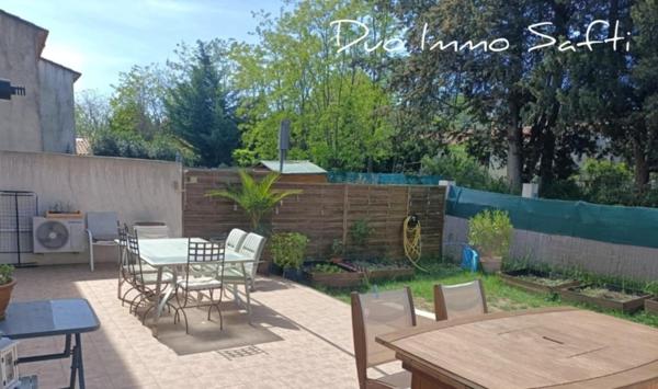 Maison mitoyenne avec jardin, terrasse, stationnements et atelier.