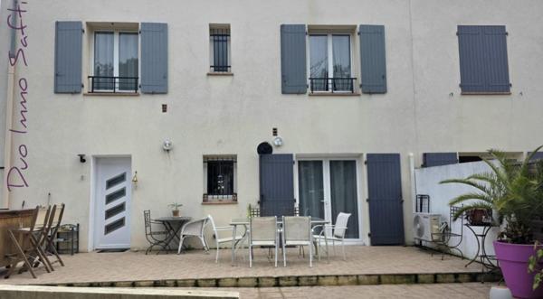 Maison mitoyenne avec jardin, terrasse, stationnements et atelier.