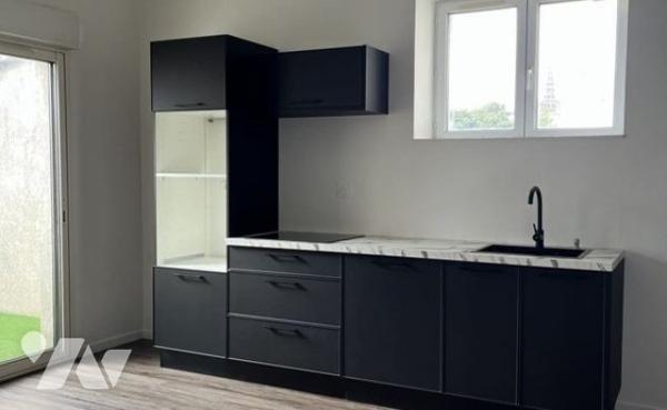 Dans une petite copropriété constituée d'un immeuble en pierre, un appartement T3