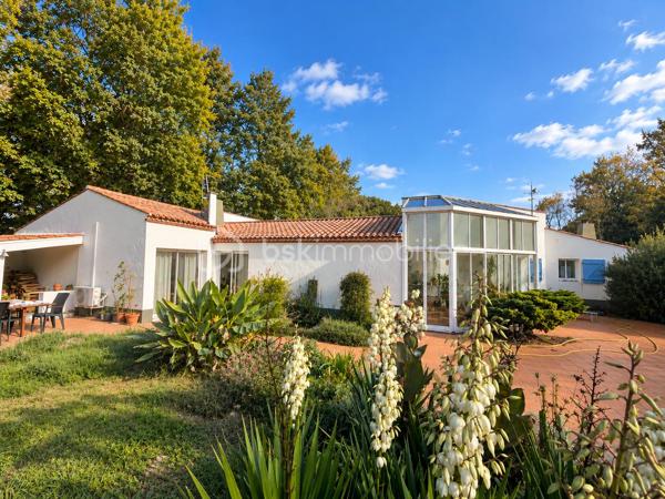 EN EXCLUSIVITÉ, dans un environnement résidentiel recherché de Challans, découvrez cette propriété de caractère, nichée au cœur d'un magnifique parc arboré de 6 330 m², entièrement clos et préservé des regards.

Construite en 1991, cette maison d'architecte de plain-pied développe environ 200 m² habitables et propose 5 chambres, de beaux volumes et une organisation intérieure particulièrement agréable pour la vie de famille.

Dès l'entrée, la maison dévoile une architecture singulière, où les ouvertures sur l'extérieur occupent une place privilégiée.
- La pièce de vie s'articule autour d'une cuisine aménagée et équipée ouverte sur la salle à manger, prolongée par un salon chaleureux doté d'une belle cheminée ouverte. Une véranda vient compléter cet ensemble et offre une transition naturelle vers la terrasse exposée sud-ouest et le jardin.
- L'espace nuit, bien distinct des pièces de vie, accueille une spacieuse suite parentale avec de nombreux rangements et dressings ainsi qu'une salle de bains équipée d'une double vasque. Quatre autres chambres, desservies par un couloir largement vitré et baigné de lumière naturelle, complètent cet espace, avec une seconde salle d'eau et des WC indépendants.
- Une buanderie et deux garages avec portes motorisées, accessibles directement depuis la maison, apportent un confort supplémentaire au quotidien.

- À l'extérieur, le parc constitue incontestablement l'un des atouts majeurs de cette propriété. Ses nombreuses essences d'arbres, ses espaces dégagés et son exposition privilégiée composent un cadre verdoyant, propice à la détente et à la vie en plein air. Un puits facilite l'entretien du jardin, tandis que la création d'une piscine peut être envisagée sous réserve des autorisations nécessaires.

Construite avec soin, cette maison d'architecte a conservé le charme et la qualité de ses prestations d'origine. Des travaux de rafraîchissement et de modernisation permettront de la personnaliser et de révéler pleinement son potentiel. L'assainissement individuel, actuellement non conforme, nécessitera une mise aux normes.
Une propriété singulière, aux volumes généreux, où architecture, espace et nature se rencontrent. Un lieu de vie idéal pour une famille en quête de tranquillité, sans renoncer à la proximité de Challans.
Au plaisir de vous accompagner dans la découverte de cette propriété. Corinne