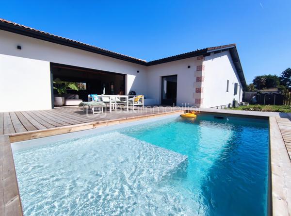 [ PLAIN PIED / 4 CHAMBRES DONT SUITE PARENTALE / PIÈCE VIE 64 M² / BELLES PRESTATIONS / PISCINE / GARAGE / POOL HOUSE / STATIONNEMENTS / TERRAIN DE PÉTANQUE / GARANTIES DÉCENNALES JUSQU'À 2035 ]

Venez découvrir cette villa familiale qui remplit tous les critères de la maison familiale idéale : lumineuse, bien agencée, fraîchement refaite à neuf et étendue, aux prestations soignées et de bon goût ! 

À Gujan-Mestras, dans le quartier de Mestras, à 2 km de la gare et de la mairie, à 2 km du littoral, et à 1 km des commerces, cette maison se situe dans une rue calme non loin de la forêt séparant Gujan-Mestras du Teich. 
Elle est desservie par les bus, avec plusieurs arrêts à 500m de la maison.

Entièrement refaite à neuf (+ extension) en 2025, vous disposerez de garanties décennales vous assurant une tranquillité d'esprit pour plusieurs années.  

Bien pensée et bien agencée, sur un seul niveau, elle se compose ainsi : 

-> Côté jour, une pièce de vie de 64 m² avec :
     - Superbe charpente apparente
     - Cheminée à foyer fermé 
     - Cuisine ouverte 
     - Triple exposition : ouest, sud, et est
     - Baie à galandage de 4.5 m ouvrant sur la terrasse

-> Côté nuit :
     - Suite parentale de 27 m² avec baie à galandage (1.5m) donnant vue sur la piscine, et équipée d'une salle de bain avec douche et baignoire + dressing + WC privatif 
     - 3 belles chambres de 10,5 m², 12 m² et 14 m² 
     - Salle d'eau spacieuse 
     - Cellier avec porte de service 

-> À l'extérieur : 
     - Piscine maçonnée 6*3 m
     - Pool House (en cours d'aménagement - vendu terminé)
     - Terrain de pétanque
     - Garage 26 m² (en cours de construction - vendu terminé)
     - Stationnement pour plusieurs véhicules

Pour le confort, la maison est équipée d'une pompe à chaleur réversible (chauffage + climatisation) et d'une cheminée à foyer fermé. 
Elle a déjà été pensée pour le raccordement des panneaux solaires et l'installation d'une cave à vin. 

Vous apprécierez les matériaux qualitatifs et aux dernières tendances : travertin véritable au sol, zelliges, baies alu à galandage, charpente traditionnelle apparente, etc. 
 -----