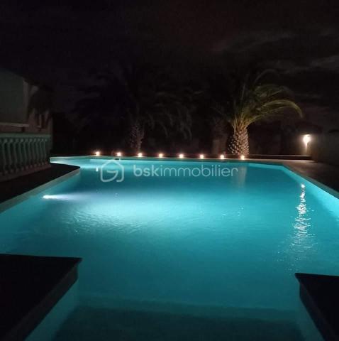 Implantée au calme absolu sur une vaste parcelle de 1 248 m², à proximité immédiate des commodités et à seulement quelques minutes des plages du Barcarès, cette magnifique villa développe 180 m² habitables, complétés par un grenier de 30 m². Vous serez séduit par ses volumes généreux, à commencer par une pièce de vie exceptionnelle d'environ 80 m², lumineuse et conviviale, prolongée par une mezzanine de 18 m². Une arrière-cuisine fonctionnelle vient parfaire l'espace de vie. La partie nuit se compose de trois chambres confortables et d'une salle de bain complète avec douche, baignoire et double vasque. Un grenier de 30 m2 peut être aménagé en 4 ème chambre ou bureau. À l'extérieur, tout est pensé pour le confort et la détente : une piscine XXL, plus de 120 m² de terrasses, un espace barbecue, une douche et des WC extérieurs. Un garage indépendant de 22 m², un local technique, un forage avec arrosage automatique, un parking béton marque de 250 m², ainsi qu'un équipement de sécurité complet (visiophone, caméras connectées) complètent ce bien d'exception, idéal pour une vie familiale ou de réception.
