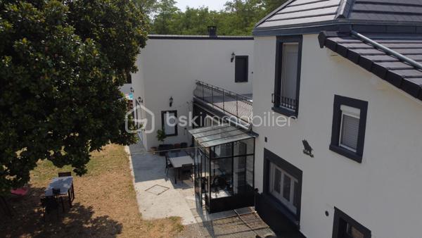 À la recherche d'une maison familiale alliant le charme de l'ancien et le confort d'une rénovation de qualité ? Cette belle demeure des années 1930 développe 178 m² habitables sur un terrain clos et arboré de 1 214 m².

Dès l'entrée, un hall dessert une cuisine indépendante aménagée et équipée, une salle à manger de plus de 23 m² et un magnifique salon de près de 45 m². Avec sa belle hauteur sous plafond, sa luminosité et son poêle à bois, cette pièce de vie offre une atmosphère chaleureuse et conviviale.

Le rez-de-chaussée comprend également une chambre, une salle d'eau, un WC indépendant, une buanderie et une chaufferie, permettant une véritable vie de plain-pied.

À l'étage, vous trouverez deux chambres indépendantes, ainsi qu'un espace parental composé de deux pièces communicantes, dont une chambre avec sa salle d'eau privative. Cette configuration offre de nombreuses possibilités d'aménagement : suite parentale, bureau, dressing ou espace parents/enfant. Une terrasse d'environ 38 m² complète ce niveau.

À l'extérieur, le jardin clos accueille une piscine, un barbecue maçonné, un grand auvent, un atelier, deux abris à bois ainsi que plusieurs places de stationnement. Une cave vient compléter l'ensemble.

Les prestations
Toiture et façades rénovées
Menuiseries PVC double vitrage
Climatisation réversible
Chauffage central au gaz et poêle à bois
Adoucisseur d'eau
Tout-à-l'égout
DPE : C

À proximité des commerces, des écoles et des transports, cette maison bénéficie d'un emplacement pratique.

À noter : la propriété est située à proximité d'un axe routier et d'une voie ferrée. Cet environnement a été pris en compte dans son positionnement tarifaire.

Une maison pleine de charme, offrant de beaux volumes, des prestations de qualité et un cadre de vie idéal pour une famille. Une visite s'impose !