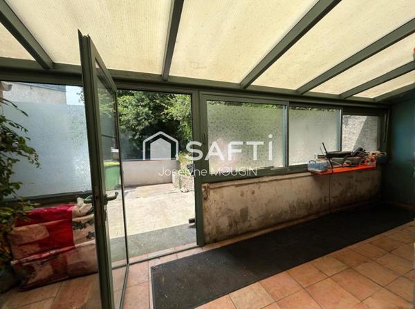 Maison avec jardin, 2 cours de stationnement, véranda.