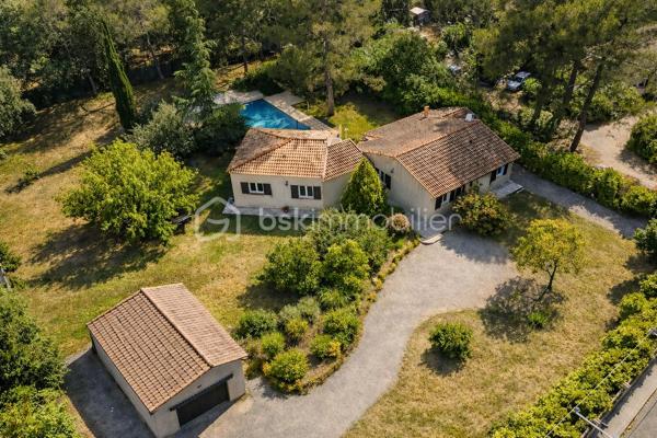 À quelques pas seulement du centre du village de Garéoult, cette propriété séduit immédiatement par la qualité de son environnement et le soin apporté à son entretien. Implantée sur un superbe terrain entièrement plat de 2 930 m², clos et harmonieusement arboré, elle offre un cadre de vie privilégié où confort, espace et intimité se conjuguent parfaitement.

Développant environ 195 m² habitables de plain-pied, la villa s’organise autour de généreux espaces de réception. Le salon, chaleureux et lumineux, s’étend sur plus de 35 m², tandis que la cuisine ouverte (récente et entièrement équipée) et la salle à manger forment un vaste ensemble d’environ 40 m², idéal pour partager des moments conviviaux. Une arrière-cuisine/buanderie vient compléter cet espace de vie particulièrement fonctionnel.

L’agencement intérieur a été pensé pour préserver le confort de chacun. L’espace nuit principal a été conçu pour préserver l’intimité de chacun. Il se compose de deux chambres d’environ 14 m² reliées par une salle d’eau communicante. À l’extrémité opposée de la maison, une suite de 21m² disposant de sa propre salle d’eau et de toilettes privatifs, forme un espace plus confidentiel et parfaitement indépendant.
Un second espace, aujourd’hui aménagé comme un logement autonome, comprend un séjour, une cuisine indépendante, une grande chambre, une salle de bains ainsi que des toilettes séparées. Cette configuration offre de nombreuses perspectives d’utilisation : hébergement de proches, activité professionnelle, rendement locatif ou encore réunification en une seule et vaste habitation familiale.

À l’abri des regards, les extérieurs invitent à la détente dans une atmosphère paisible et soignée. Le jardin plat de 2 930 m² met en valeur une élégante piscine habillée en pierres de Bali, sécurisée par un volet roulant électrique. Une vaste terrasse en travertin de plus de 200m² aménagée entoure la piscine et prolonge naturellement les espaces de vie vers l’extérieur. Plusieurs lieux de détente ont été créés au sein de la propriété afin de profiter pleinement de chaque instant, en toute tranquillité dont un kiosque et une pergola.
Deux accès distincts par portails facilitent l’entrée sur la propriété, qui dispose également d’un garage indépendant d’environ 35 m².

Grâce à son agencement particulièrement modulable, cette propriété se prête idéalement à un projet de regroupement familial, à une activité de chambres d'hôtes, à l'accueil d'une clientèle saisonnière ou encore à l'exercice d'une activité professionnelle indépendante.

Si l'ensemble a bénéficié d'un entretien rigoureux au fil des années, quelques travaux de remise au goût du jour permettront de valoriser davantage ses beaux volumes et son remarquable potentiel.

N'hésitez plus et contactez nous dès à présent pour de plus amples informations et organiser votre visite!