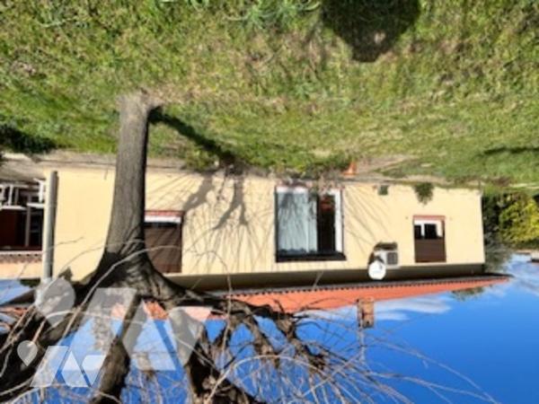 Maison d'habitation de plain pied avec garage édifiée sur terrain clos et arboré dans quartier calme
