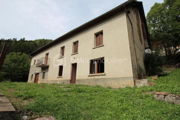 Amoureux de bâtisses anciennes et de projets de rénovation, découvrez ce corps de ferme offrant de beaux volumes et de nombreuses possibilités d'aménagement, dans un environnement naturel privilégié.

La partie habitation existante se développe sur plusieurs pièces et conserve le caractère d'une maison ancienne. Elle nécessite aujourd'hui une rénovation permettant à ses futurs propriétaires de repenser les espaces selon leur projet et leurs besoins.

Le véritable atout de cette propriété réside également dans ses importants volumes annexes : grange, dépendances et vastes combles offrent un potentiel particulièrement intéressant pour un projet familial, une résidence secondaire ou la création d'espaces complémentaires, sous réserve des autorisations nécessaires.

À l'extérieur, la maison dispose d'une agréable esplanade sur le devant, offrant un espace de vie extérieur au niveau de l'habitation. Le jardin se développe ensuite en contrebas, sur un terrain en pente, dans un environnement montagnard avec de belles vues sur les reliefs environnants.

Une propriété destinée avant tout aux acquéreurs recherchant une bâtisse authentique à rénover, de l'espace et un véritable potentiel de transformation, plutôt qu'une maison déjà remise au goût du jour.