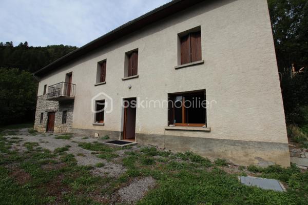 Amoureux de bâtisses anciennes et de projets de rénovation, découvrez ce corps de ferme offrant de beaux volumes et de nombreuses possibilités d'aménagement, dans un environnement naturel privilégié.

La partie habitation existante se développe sur plusieurs pièces et conserve le caractère d'une maison ancienne. Elle nécessite aujourd'hui une rénovation permettant à ses futurs propriétaires de repenser les espaces selon leur projet et leurs besoins.

Le véritable atout de cette propriété réside également dans ses importants volumes annexes : grange, dépendances et vastes combles offrent un potentiel particulièrement intéressant pour un projet familial, une résidence secondaire ou la création d'espaces complémentaires, sous réserve des autorisations nécessaires.

À l'extérieur, la maison dispose d'une agréable esplanade sur le devant, offrant un espace de vie extérieur au niveau de l'habitation. Le jardin se développe ensuite en contrebas, sur un terrain en pente, dans un environnement montagnard avec de belles vues sur les reliefs environnants.

Une propriété destinée avant tout aux acquéreurs recherchant une bâtisse authentique à rénover, de l'espace et un véritable potentiel de transformation, plutôt qu'une maison déjà remise au goût du jour.