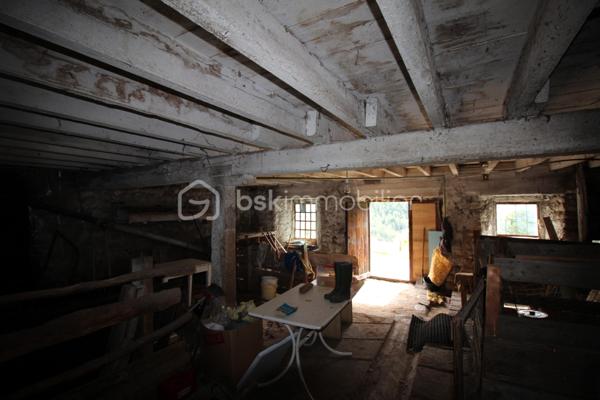 Amoureux de bâtisses anciennes et de projets de rénovation, découvrez ce corps de ferme offrant de beaux volumes et de nombreuses possibilités d'aménagement, dans un environnement naturel privilégié.

La partie habitation existante se développe sur plusieurs pièces et conserve le caractère d'une maison ancienne. Elle nécessite aujourd'hui une rénovation permettant à ses futurs propriétaires de repenser les espaces selon leur projet et leurs besoins.

Le véritable atout de cette propriété réside également dans ses importants volumes annexes : grange, dépendances et vastes combles offrent un potentiel particulièrement intéressant pour un projet familial, une résidence secondaire ou la création d'espaces complémentaires, sous réserve des autorisations nécessaires.

À l'extérieur, la maison dispose d'une agréable esplanade sur le devant, offrant un espace de vie extérieur au niveau de l'habitation. Le jardin se développe ensuite en contrebas, sur un terrain en pente, dans un environnement montagnard avec de belles vues sur les reliefs environnants.

Une propriété destinée avant tout aux acquéreurs recherchant une bâtisse authentique à rénover, de l'espace et un véritable potentiel de transformation, plutôt qu'une maison déjà remise au goût du jour.