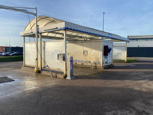 centre de lavages situé dans une zone commerciale, entre un NOZ et un Concessionnaire de motos