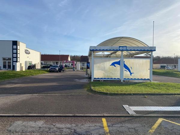 centre de lavages situé dans une zone commerciale, entre un NOZ et un Concessionnaire de motos