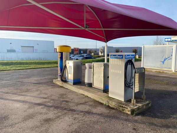 centre de lavages situé dans une zone commerciale, entre un NOZ et un Concessionnaire de motos