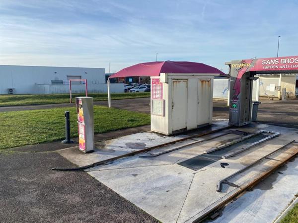 centre de lavages situé dans une zone commerciale, entre un NOZ et un Concessionnaire de motos
