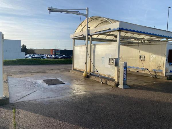 centre de lavages situé dans une zone commerciale, entre un NOZ et un Concessionnaire de motos
