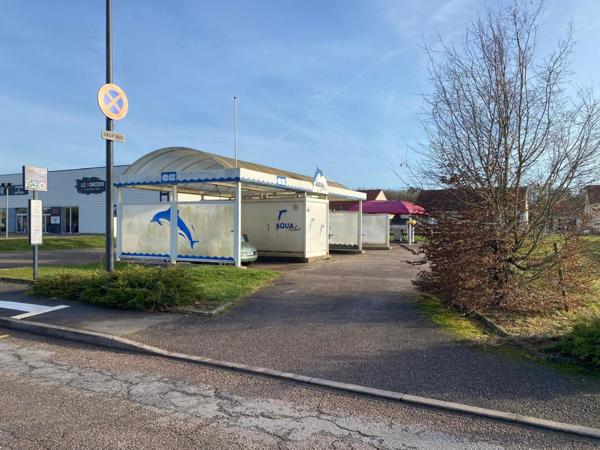 centre de lavages situé dans une zone commerciale, entre un NOZ et un Concessionnaire de motos