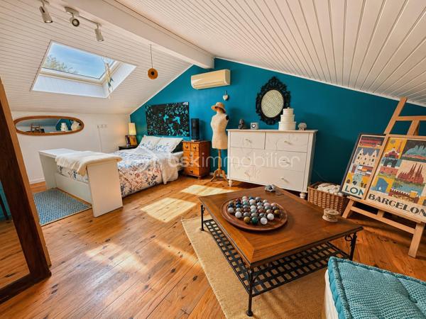 En exclusivité, idéalement située en plein centre de Labastidette, cette villa d’architecte bénéficie d’un emplacement pratique, à proximité des commerces, des services et des commodités du quotidien. Elle permet de profiter d’un cadre de vie résidentiel tout en restant facilement accessible depuis Muret et l’agglomération toulousaine.

Au cœur d’un environnement verdoyant, sur une parcelle paysagée d’environ 1 200 m², la propriété qui développe 220m2, séduit par son architecture singulière, ses volumes généreux, ses matériaux à la fois esthétiques et écologiques mais aussi par son efficience énergétique. Elle propose aujourd’hui 3 chambres, dont une suite parentale, ainsi que de nombreux espaces de vie conçus pour conjuguer confort, convivialité et ouverture sur les extérieurs. La pièce de réception s’organise autour d’un vaste séjour agrémenté d’une cuisine ouverte équipée et d’un espace bureau pouvant être isolé. Les ouvertures prolongent naturellement les espaces intérieurs vers les terrasses et le jardin, créant une continuité agréable entre la maison et son environnement paysager. L’étage s’ouvre sur un joli salon cosy et un couloir desservant une vaste chambre disposant de son bureau et son coin salon/détente.  

La propriété dispose également d’une piscine couverte et chauffée, véritable espace de détente utilisable en toute saison, ainsi que d’un lodge indépendant d’environ 45 m². Ce dernier, particulièrement chaleureux et apaisant, est intégralement voué à la détente. Composé d’un coin salon, d’un espace douche, d’un sauna ainsi que d’un grand jacuzzi, il s’ouvre sur la piscine lui conférant ainsi une accessibilité même en hiver.

Les extérieurs, soigneusement végétalisés, bénéficient de plusieurs espaces de vie et de stationnement. Un carport complète l’ensemble.

La maison est équipée d’une installation de chauffage au sol, d’un puits et de solutions énergétiques performantes (matériaux techniques, géothermie, panneaux solaires…). Elle bénéficie d’un DPE classé B, témoignant d’un niveau de performance énergétique favorable.

Cette propriété s’adresse à une clientèle recherchant un bien de caractère, aux volumes généreux, bénéficiant d’équipements rares et d’un cadre de vie privilégié aux portes de l’agglomération toulousaine.