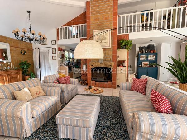 En exclusivité, idéalement située en plein centre de Labastidette, cette villa d’architecte bénéficie d’un emplacement pratique, à proximité des commerces, des services et des commodités du quotidien. Elle permet de profiter d’un cadre de vie résidentiel tout en restant facilement accessible depuis Muret et l’agglomération toulousaine.

Au cœur d’un environnement verdoyant, sur une parcelle paysagée d’environ 1 200 m², la propriété qui développe 220m2, séduit par son architecture singulière, ses volumes généreux, ses matériaux à la fois esthétiques et écologiques mais aussi par son efficience énergétique. Elle propose aujourd’hui 3 chambres, dont une suite parentale, ainsi que de nombreux espaces de vie conçus pour conjuguer confort, convivialité et ouverture sur les extérieurs. La pièce de réception s’organise autour d’un vaste séjour agrémenté d’une cuisine ouverte équipée et d’un espace bureau pouvant être isolé. Les ouvertures prolongent naturellement les espaces intérieurs vers les terrasses et le jardin, créant une continuité agréable entre la maison et son environnement paysager. L’étage s’ouvre sur un joli salon cosy et un couloir desservant une vaste chambre disposant de son bureau et son coin salon/détente.  

La propriété dispose également d’une piscine couverte et chauffée, véritable espace de détente utilisable en toute saison, ainsi que d’un lodge indépendant d’environ 45 m². Ce dernier, particulièrement chaleureux et apaisant, est intégralement voué à la détente. Composé d’un coin salon, d’un espace douche, d’un sauna ainsi que d’un grand jacuzzi, il s’ouvre sur la piscine lui conférant ainsi une accessibilité même en hiver.

Les extérieurs, soigneusement végétalisés, bénéficient de plusieurs espaces de vie et de stationnement. Un carport complète l’ensemble.

La maison est équipée d’une installation de chauffage au sol, d’un puits et de solutions énergétiques performantes (matériaux techniques, géothermie, panneaux solaires…). Elle bénéficie d’un DPE classé B, témoignant d’un niveau de performance énergétique favorable.

Cette propriété s’adresse à une clientèle recherchant un bien de caractère, aux volumes généreux, bénéficiant d’équipements rares et d’un cadre de vie privilégié aux portes de l’agglomération toulousaine.