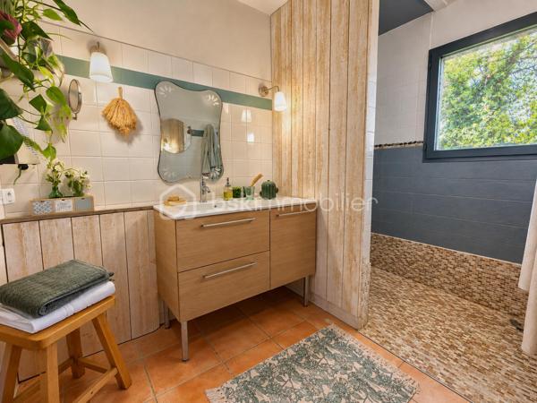 En exclusivité, idéalement située en plein centre de Labastidette, cette villa d’architecte bénéficie d’un emplacement pratique, à proximité des commerces, des services et des commodités du quotidien. Elle permet de profiter d’un cadre de vie résidentiel tout en restant facilement accessible depuis Muret et l’agglomération toulousaine.

Au cœur d’un environnement verdoyant, sur une parcelle paysagée d’environ 1 200 m², la propriété qui développe 220m2, séduit par son architecture singulière, ses volumes généreux, ses matériaux à la fois esthétiques et écologiques mais aussi par son efficience énergétique. Elle propose aujourd’hui 3 chambres, dont une suite parentale, ainsi que de nombreux espaces de vie conçus pour conjuguer confort, convivialité et ouverture sur les extérieurs. La pièce de réception s’organise autour d’un vaste séjour agrémenté d’une cuisine ouverte équipée et d’un espace bureau pouvant être isolé. Les ouvertures prolongent naturellement les espaces intérieurs vers les terrasses et le jardin, créant une continuité agréable entre la maison et son environnement paysager. L’étage s’ouvre sur un joli salon cosy et un couloir desservant une vaste chambre disposant de son bureau et son coin salon/détente.  

La propriété dispose également d’une piscine couverte et chauffée, véritable espace de détente utilisable en toute saison, ainsi que d’un lodge indépendant d’environ 45 m². Ce dernier, particulièrement chaleureux et apaisant, est intégralement voué à la détente. Composé d’un coin salon, d’un espace douche, d’un sauna ainsi que d’un grand jacuzzi, il s’ouvre sur la piscine lui conférant ainsi une accessibilité même en hiver.

Les extérieurs, soigneusement végétalisés, bénéficient de plusieurs espaces de vie et de stationnement. Un carport complète l’ensemble.

La maison est équipée d’une installation de chauffage au sol, d’un puits et de solutions énergétiques performantes (matériaux techniques, géothermie, panneaux solaires…). Elle bénéficie d’un DPE classé B, témoignant d’un niveau de performance énergétique favorable.

Cette propriété s’adresse à une clientèle recherchant un bien de caractère, aux volumes généreux, bénéficiant d’équipements rares et d’un cadre de vie privilégié aux portes de l’agglomération toulousaine.