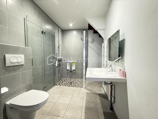 À 13 km de Voiron et 35 km de Grenoble, cette maison de village implantée en plein coeur d’Izeaux offre 142,82 m² habitables sur deux niveaux. Idéale pour une famille souhaitant s’installer dans un village animé, avec commerces et écoles à pied, à proximité des axes de transport vers Voiron et Grenoble.

Rez-de-chaussée :
Dès l’entrée, la maison révèle ses volumes : un salon de 24 m², belle pièce de vie à s’approprier, s’ouvre sur une cuisine spacieuse de 23 m² avec accès direct à la cour. Un cellier de 6,45 m² complète l’espace. La salle d’eau, entièrement neuve, avec douche à l’italienne et WC, a été conçue et aménagée pour l’accessibilité PMR.

Étage :
Quatre chambres dont une de 15 m² avec accès à un balcon, une de 12 m²,  de 11 m² et une de 10 m². Une grande salle de bain de 10 m² avec double vasque, douche et WC dessert l’ensemble.
Combles :
Environ 25 m² aménageables — une opportunité supplémentaire pour créer un espace bureau, une chambre d’amis ou une salle de jeux.

Extérieur :
À l’arrière, une cour  prolongent agréablement la maison pour profiter des beaux jours.
Côté stationnement, la maison dispose d'une place privative devant l'entrée. Un parking extérieur commun, à moins de 100 mètres, permet de garer facilement plusieurs véhicules.

Cadre de vie :
Le village d’Izeaux propose un cadre de vie paisible avec ses commerces de proximité, son marché hebdomadaire et ses écoles sur la commune. Les amateurs de nature profiteront des nombreux sentiers de randonnée et du jardin public situé à deux pas.

Travaux réalisés et équipements  :
Toiture refaite en 2023
Fenêtres PVC double vitrage
Chauffage : poêle à granulés (2017) + appoint électrique
Tout-à-l’égout

Travaux à prévoir
Rafraîchissement intérieur : remise en peinture de l'ensemble des pièces, rénovation des sols de la cuisine et du salon.
Travaux préconisés par l’audit énergétique :
Renforcement de l’isolation des murs (construction en pisé avec doublage insuffisant), installation d’une VMC, remplacement du chauffe-eau et installation d'une pompe à chaleur 
Estimation des coûts annuels d’énergie : entre 4 400 € et 6 000 € / an (estimation établie sur la base des prix de l’énergie 2021-2023).