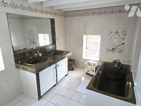 Maison familiale avec dépendances et grand terrain arboré.