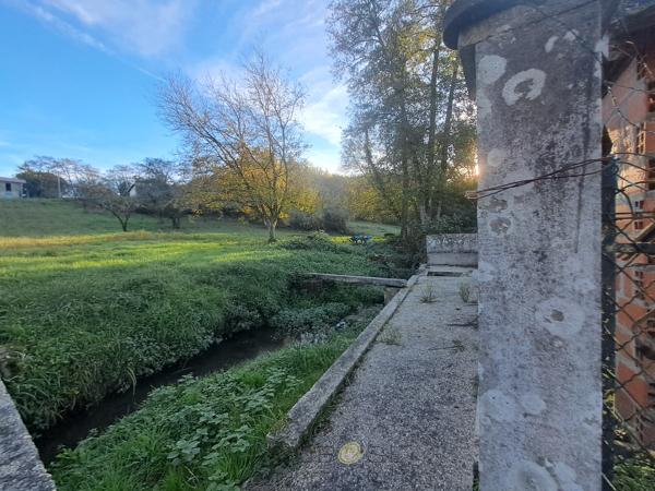 Maison traditionnelle de plain-pied avec ses terres et son ruisseau