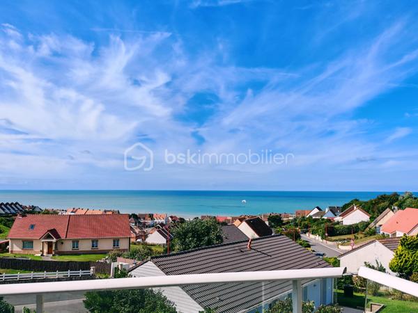 Dans un cadre privilégié à Équihen-Plage, venez découvrir cette jolie maison bel étage semi-individuelle de 108 m² habitables, située sur une parcelle de 405 m² et offrant une vue mer exceptionnelle depuis chaque niveau.
Le premier étage constitue l’espace de vie, avec une entrée disposant d’un espace vestiaire, un séjour profitant d’une magnifique vue mer à 180°, une cuisine équipée et un balcon d’environ 4 m² pour profiter pleinement du panorama. Un WC indépendant complète ce niveau.
Au deuxième étage, vous trouverez trois chambres, là encore avec une belle vue sur la mer, ainsi qu’une salle de bains. 
Le rez-de-chaussée est consacré aux espaces annexes avec un garage, une buanderie, un cellier ainsi qu’une seconde cuisine équipée. Cette dernière profite elle aussi d’une belle vue sur la mer et pourrait facilement être repensée selon vos envies.
Un grenier vient compléter l’ensemble et offre un espace de rangement ou un potentiel d’aménagement supplémentaire.
À l’extérieur, la maison dispose d’un grand jardin, d’une dépendance et de plusieurs places de stationnement.
Une maison à rénover, mais qui offre un potentiel rare grâce à ses beaux volumes et surtout à cette vue mer omniprésente et exceptionnelle. Un bien idéal pour ceux qui souhaitent créer une maison à leur image dans un environnement privilégié.