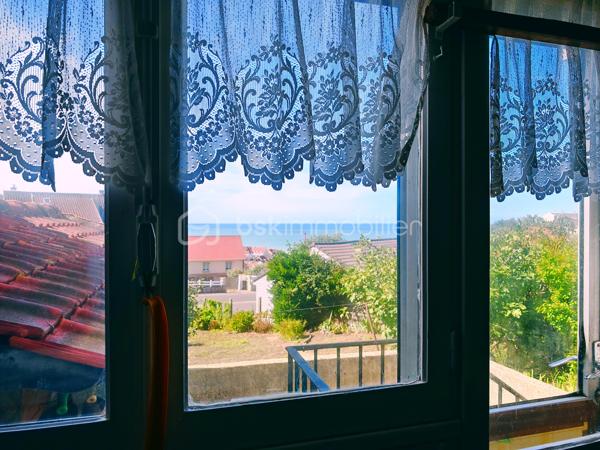 Dans un cadre privilégié à Équihen-Plage, venez découvrir cette jolie maison bel étage semi-individuelle de 108 m² habitables, située sur une parcelle de 405 m² et offrant une vue mer exceptionnelle depuis chaque niveau.
Le premier étage constitue l’espace de vie, avec une entrée disposant d’un espace vestiaire, un séjour profitant d’une magnifique vue mer à 180°, une cuisine équipée et un balcon d’environ 4 m² pour profiter pleinement du panorama. Un WC indépendant complète ce niveau.
Au deuxième étage, vous trouverez trois chambres, là encore avec une belle vue sur la mer, ainsi qu’une salle de bains. 
Le rez-de-chaussée est consacré aux espaces annexes avec un garage, une buanderie, un cellier ainsi qu’une seconde cuisine équipée. Cette dernière profite elle aussi d’une belle vue sur la mer et pourrait facilement être repensée selon vos envies.
Un grenier vient compléter l’ensemble et offre un espace de rangement ou un potentiel d’aménagement supplémentaire.
À l’extérieur, la maison dispose d’un grand jardin, d’une dépendance et de plusieurs places de stationnement.
Une maison à rénover, mais qui offre un potentiel rare grâce à ses beaux volumes et surtout à cette vue mer omniprésente et exceptionnelle. Un bien idéal pour ceux qui souhaitent créer une maison à leur image dans un environnement privilégié.