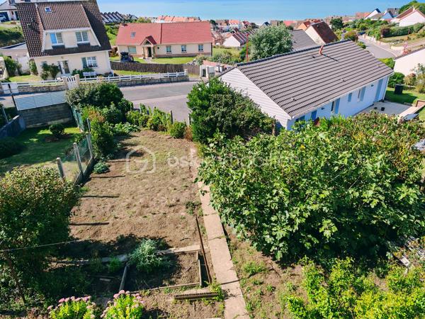 Dans un cadre privilégié à Équihen-Plage, venez découvrir cette jolie maison bel étage semi-individuelle de 108 m² habitables, située sur une parcelle de 405 m² et offrant une vue mer exceptionnelle depuis chaque niveau.
Le premier étage constitue l’espace de vie, avec une entrée disposant d’un espace vestiaire, un séjour profitant d’une magnifique vue mer à 180°, une cuisine équipée et un balcon d’environ 4 m² pour profiter pleinement du panorama. Un WC indépendant complète ce niveau.
Au deuxième étage, vous trouverez trois chambres, là encore avec une belle vue sur la mer, ainsi qu’une salle de bains. 
Le rez-de-chaussée est consacré aux espaces annexes avec un garage, une buanderie, un cellier ainsi qu’une seconde cuisine équipée. Cette dernière profite elle aussi d’une belle vue sur la mer et pourrait facilement être repensée selon vos envies.
Un grenier vient compléter l’ensemble et offre un espace de rangement ou un potentiel d’aménagement supplémentaire.
À l’extérieur, la maison dispose d’un grand jardin, d’une dépendance et de plusieurs places de stationnement.
Une maison à rénover, mais qui offre un potentiel rare grâce à ses beaux volumes et surtout à cette vue mer omniprésente et exceptionnelle. Un bien idéal pour ceux qui souhaitent créer une maison à leur image dans un environnement privilégié.