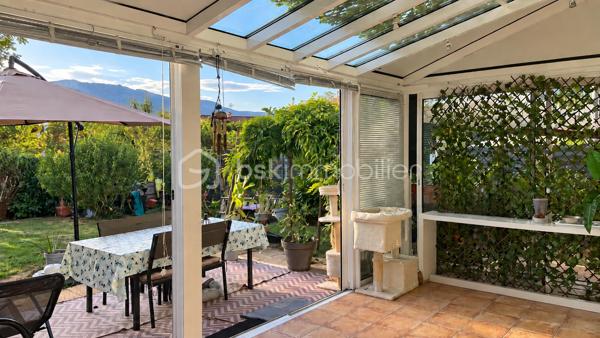 À Valleiry, dans un environnement résidentiel, profitez d’un cadre de vie familial, calme et pratique, à proximité de Genève.

UNE MAISON PENSÉE POUR LA VIE DE FAMILLE
Construite en 2004, cette maison de 7 pièces offre de beaux volumes et une organisation idéale pour une vie de famille confortable.
Répartie sur trois niveaux, elle propose 4 chambres, 2 salles de bains, 3 WC, un garage attenant, deux places de stationnement et un jardin clos.
Implantée sur une parcelle d’environ 274 m², au sein d’un lotissement résidentiel calme, la maison est mitoyenne par un seul côté, au niveau du garage et de la chambre située au-dessus, tout en conservant une réelle indépendance dans ses espaces de vie.
Elle bénéficie d’une situation préservée, sans accès direct sur la route et à l’écart des nuisances sonores.

LE COUP DE CŒUR : UNE VÉRANDA CHAUFFÉE DE 20 M²
Baignée de lumière et largement ouverte sur le jardin, la véranda prolonge agréablement les espaces de vie et crée une atmosphère chaleureuse en toute saison.
Salle à manger conviviale, salon détente, salle de jeux, coin lecture ou espace pour recevoir : chacun pourra imaginer cette pièce selon son mode de vie.

REZ-DE-JARDIN : DES ESPACES FLUIDES ET LUMINEUX
Le rez-de-jardin offre une distribution agréable et fonctionnelle.
L’entrée ouvre sur une belle pièce de vie lumineuse d’environ 36 m², composée d’un séjour et d’une cuisine ouverte, avec un premier WC indépendant.
La pièce de vie se prolonge naturellement vers la véranda ouverte sur le jardin.
Le garage attenant, accessible également depuis la véranda, apporte un espace pratique supplémentaire au quotidien.

PREMIER ÉTAGE : MEZZANINE, 2 CHAMBRES ET SUITE PARENTALE
Une spacieuse mezzanine d’environ 16 m² offre un espace polyvalent, idéal pour aménager un bureau, un coin lecture, une salle de jeux ou un espace TV.
Ce niveau comprend également deux chambres, dont une chambre parentale avec salle de bains privative, ainsi qu’un deuxième WC.

DEUXIÈME ÉTAGE : 2 CHAMBRES SUPPLÉMENTAIRES
Le dernier niveau accueille deux autres chambres, des rangements, une seconde salle de bains et un troisième WC, offrant à chacun son propre espace.

CONFORT ET CHAUFFAGE
Le chauffage principal est assuré par un poêle à granulés, relayé si besoin par des convecteurs électriques.

SECTEUR ET COMMODITÉS
La situation est idéale pour concilier vie de famille, quotidien pratique et déplacements vers le bassin genevois.
La douane de Chancy permet de rejoindre rapidement Genève et constitue un véritable atout pour les actifs frontaliers souhaitant profiter d’un cadre résidentiel calme tout en restant proches de leur lieu de travail.
Pour les familles, le groupe scolaire Les Primevères, de la maternelle au CM2, est accessible à pied, tandis que le Collège du Vuache à Vulbens se situe à environ 10 minutes, avec des transports scolaires au départ de Valleiry.
Au quotidien, tout est à portée de main : supermarché, boulangeries, pharmacie, professionnels de santé, banques, bureau de poste, restaurants et gare SNCF.

À DÉCOUVRIR
Un bien familial complet, fonctionnel et idéalement situé, qui conjugue espace, calme, praticité et proximité de Genève.