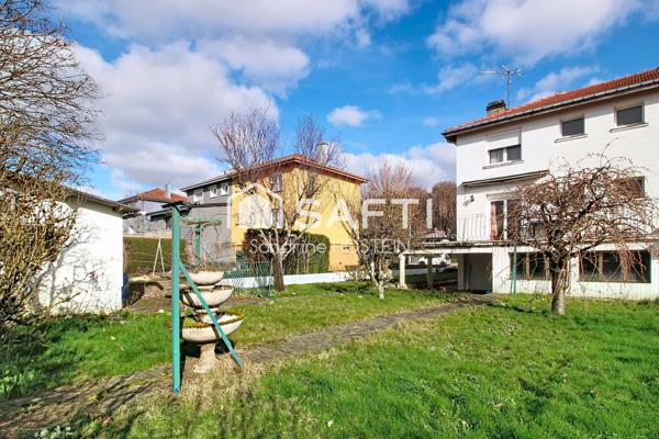 Maison jumelée de 100m2 hab avec grand garage, terrasse et jardin.