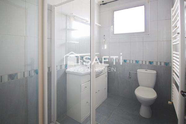 Maison jumelée de 100m2 hab avec grand garage, terrasse et jardin.