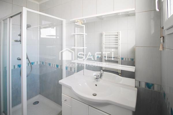 Maison jumelée de 100m2 hab avec grand garage, terrasse et jardin.