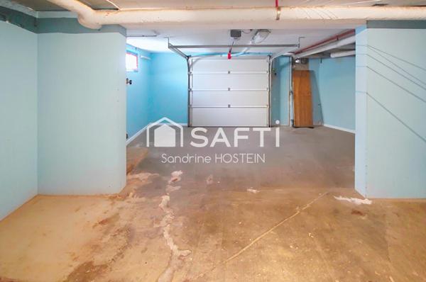 Maison jumelée de 100m2 hab avec grand garage, terrasse et jardin.