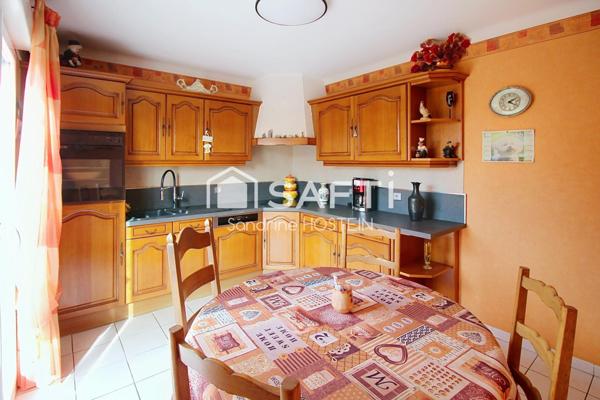 Maison jumelée de 100m2 hab avec grand garage, terrasse et jardin.