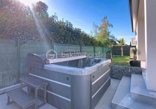 A 8 min de Saint Sulpice, sur la petite commune de Buzet sur Tarn, 
Au cœur d’un quartier calme, cette maison contemporaine de plain-pied, achevée en 2025, séduira par son confort moderne et son ambiance chaleureuse.

Édifiée sur une parcelle entièrement clôturée de 469 m², elle développe une surface habitable d’environ 139 m², parfaitement pensée pour offrir un cadre de vie à la fois fonctionnel et convivial.

Dès l’entrée, un espace accueillant doté de placards intégrés, d’un toilette indépendant et d’une buanderie pratique.
Vous découvrirez ensuite une vaste pièce de vie de 52 m², baignée de lumière grâce à ses larges ouvertures. Cet espace réunit un salon confortable et une belle cuisine à vivre, véritable cœur de la maison, ouvrant directement sur une terrasse intime agrémentée d’un jacuzzi, pour profiter pleinement des moments de détente en extérieur.

L’espace nuit, bien séparé, offre 4 chambres :
Deux d’entre elles disposent de salles d’eau privatives, tandis que la suite parentale bénéficie d’un dressing sur mesure et de sa propre salle d’eau. La troisième chambre, elle possède un placards aménagés et se trouve à coté de la salle de bains principale, équipée d’une baignoire et d’une douche, ainsi qu’un deuxième toilette.

Côté pratique, la maison propose un garage isolé et carrelé d’environ 20 m², ainsi qu’un carport.

Construite selon les normes RT2020, elle bénéficie de prestations haut de gamme :
- Chauffage par climatisation gainable,
- Menuiseries aluminium et volets motorisés,
- Portail électrique
- Isolation performante garantissant un excellent confort thermique et acoustique.

Alliant modernité, confort et tranquillité, cette maison contemporaine saura répondre aux attentes des familles souhaitant s’installer dans un cadre de vie agréable, à proximité de Toulouse (15min) et des commodités principales.