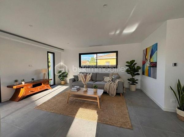 A 8 min de Saint Sulpice, sur la petite commune de Buzet sur Tarn, 
Au cœur d’un quartier calme, cette maison contemporaine de plain-pied, achevée en 2025, séduira par son confort moderne et son ambiance chaleureuse.

Édifiée sur une parcelle entièrement clôturée de 469 m², elle développe une surface habitable d’environ 139 m², parfaitement pensée pour offrir un cadre de vie à la fois fonctionnel et convivial.

Dès l’entrée, un espace accueillant doté de placards intégrés, d’un toilette indépendant et d’une buanderie pratique.
Vous découvrirez ensuite une vaste pièce de vie de 52 m², baignée de lumière grâce à ses larges ouvertures. Cet espace réunit un salon confortable et une belle cuisine à vivre, véritable cœur de la maison, ouvrant directement sur une terrasse intime agrémentée d’un jacuzzi, pour profiter pleinement des moments de détente en extérieur.

L’espace nuit, bien séparé, offre 4 chambres :
Deux d’entre elles disposent de salles d’eau privatives, tandis que la suite parentale bénéficie d’un dressing sur mesure et de sa propre salle d’eau. La troisième chambre, elle possède un placards aménagés et se trouve à coté de la salle de bains principale, équipée d’une baignoire et d’une douche, ainsi qu’un deuxième toilette.

Côté pratique, la maison propose un garage isolé et carrelé d’environ 20 m², ainsi qu’un carport.

Construite selon les normes RT2020, elle bénéficie de prestations haut de gamme :
- Chauffage par climatisation gainable,
- Menuiseries aluminium et volets motorisés,
- Portail électrique
- Isolation performante garantissant un excellent confort thermique et acoustique.

Alliant modernité, confort et tranquillité, cette maison contemporaine saura répondre aux attentes des familles souhaitant s’installer dans un cadre de vie agréable, à proximité de Toulouse (15min) et des commodités principales.