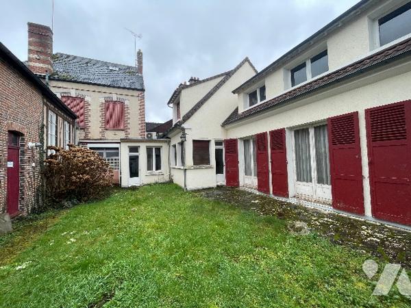 Immeuble comprenant une maison avec jardin et un commerce