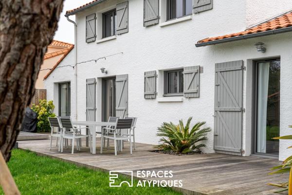 Jolie familiale baignée de lumière, terrasse bois et jardin paysagé.