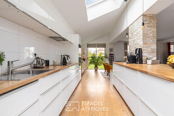 Jolie familiale baignée de lumière, terrasse bois et jardin paysagé.