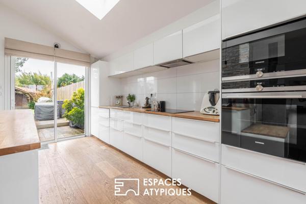Jolie familiale baignée de lumière, terrasse bois et jardin paysagé.