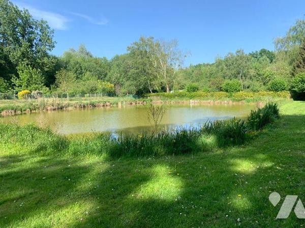 Beau terrain avec plan d'eau et un abri pour caravane.